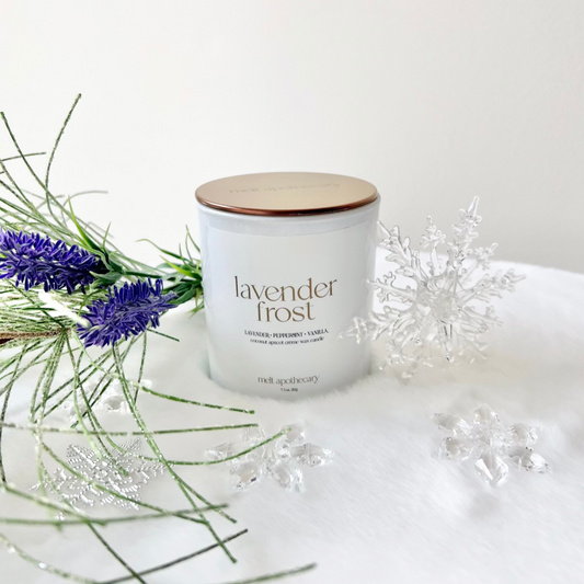 lavender frost candle in snow with fresh lavender and plastic snowflakes